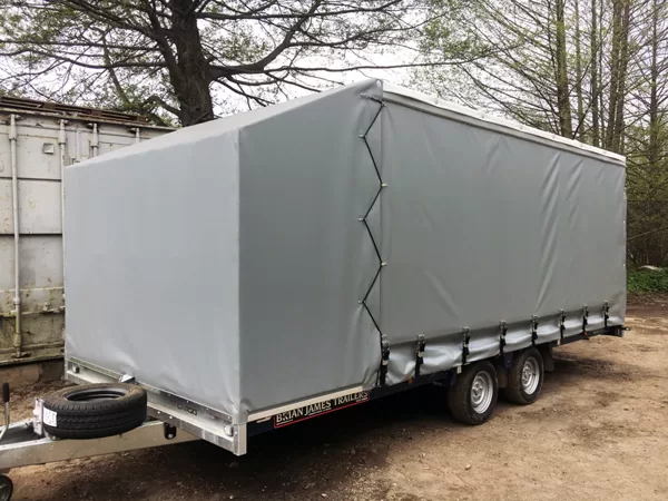 Auto pārvadāšanas piekabe ar atvelkamiem sānu aizkariem